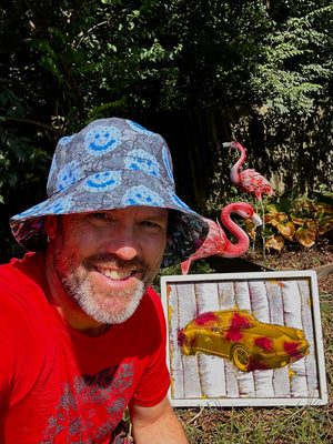 smiley blue flowers on grey clouds / paypaya leaves and magenta flowers with some blue Reversible bucket hat